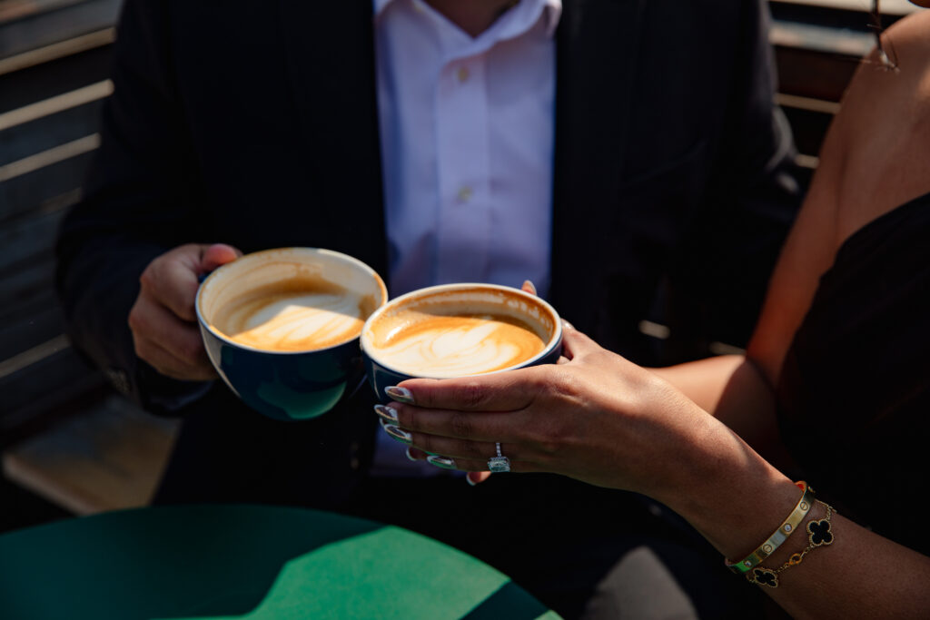 Couple clinks coffee cups in San Francisco. 