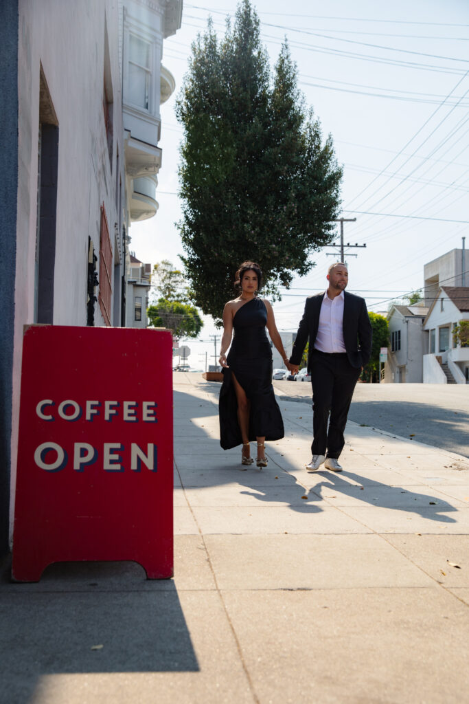 Couple walks in front of coffee shop in San Francisco. 